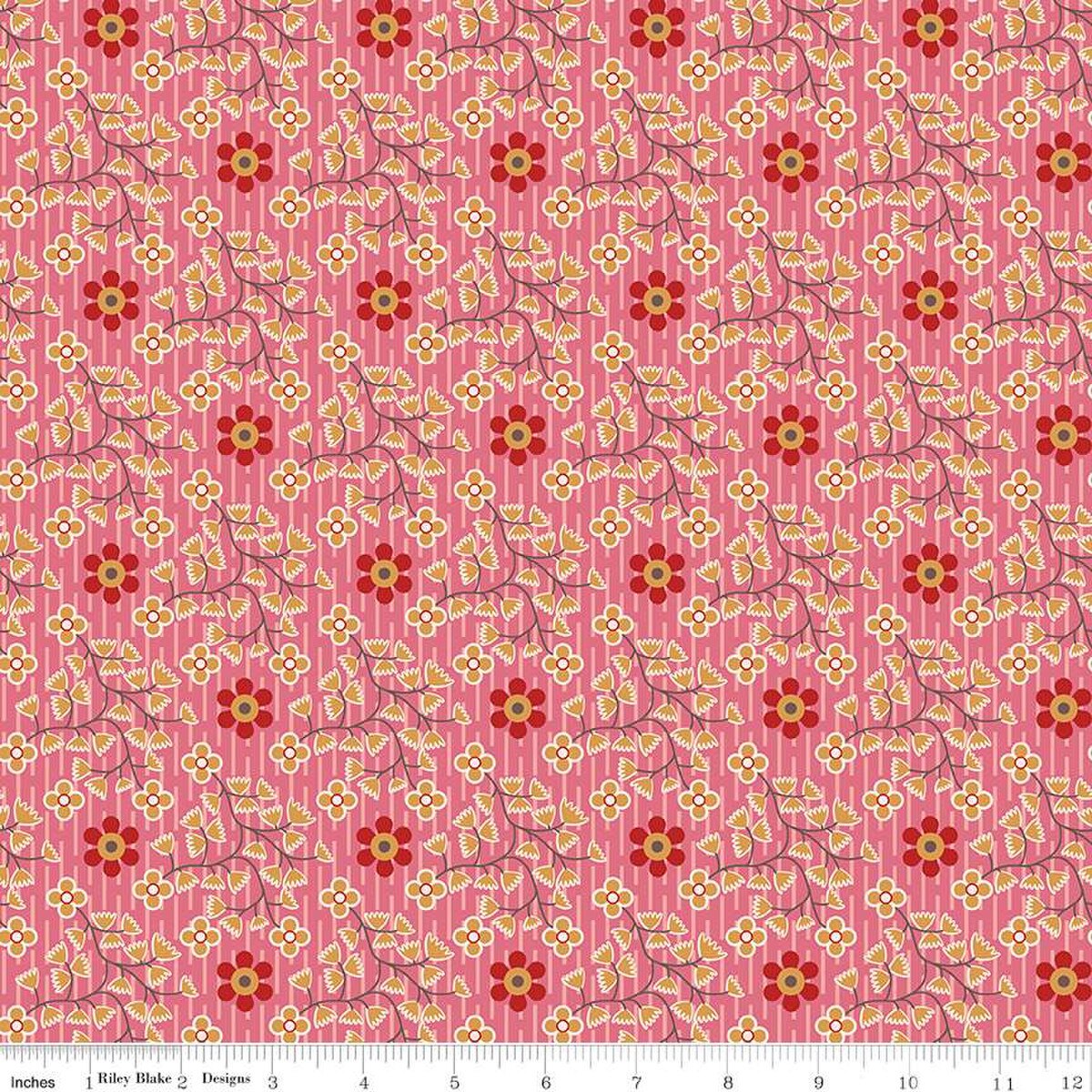 Floral patterned fabric with red and yellow flowers on a pink background